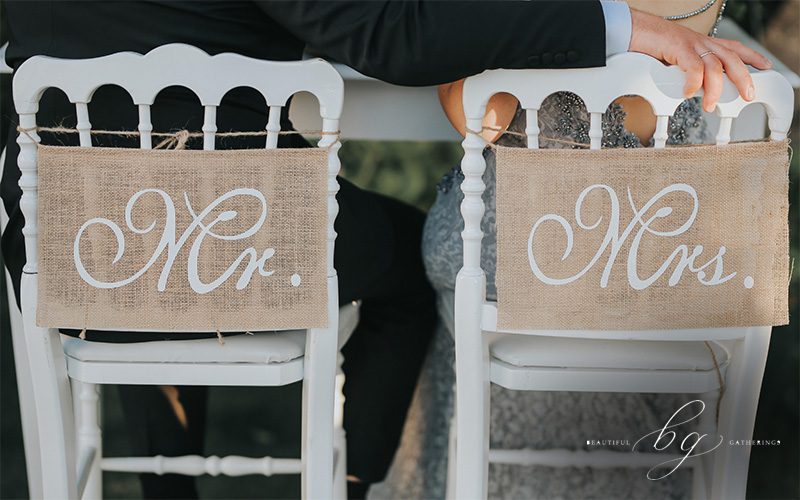 Couple sitting on wedding chairs with 