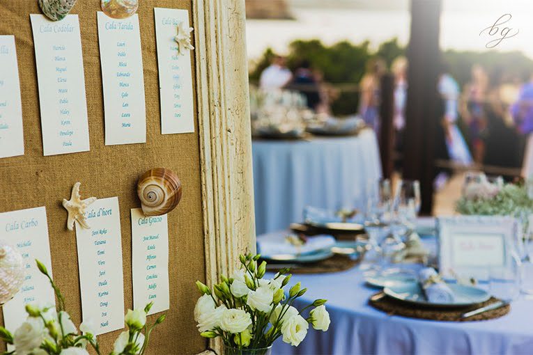 Beach-themed wedding seating chart and table setting.